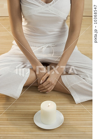 Cross-legged woman's torso with candle 10368547