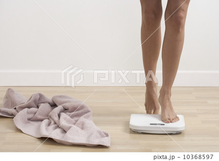 Feet stepping onto bathroom scale 10368597