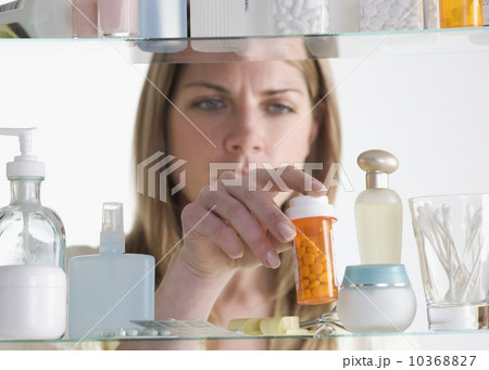 Woman removing medicine from cabinet 10368827