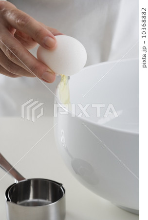 Hand cracking egg into bowl 10368882