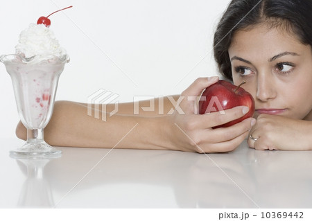 Woman with apple wanting ice cream sundae 10369442