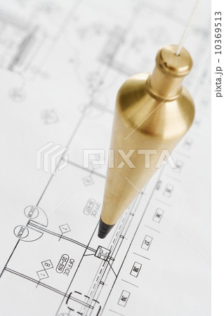 Plumb bob above blueprints 10369513