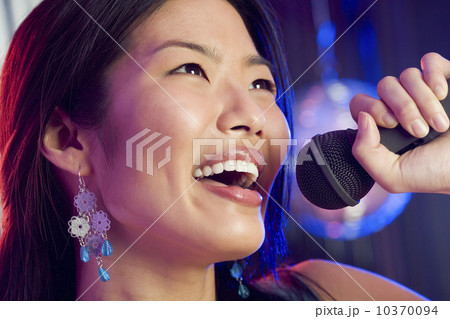 Woman singing into microphone 10370094