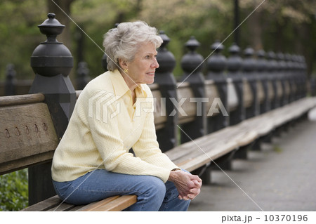 Portrait of woman sitting on park bench 10370196