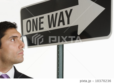Businessman looking at one way sign Businessman looking at one way sign 10370236