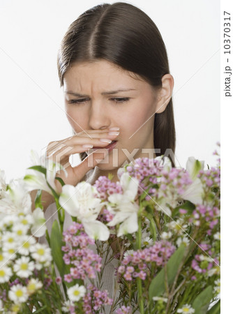 Woman about to sneeze and holding flowers 10370317