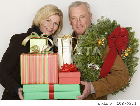 Couple holding Christmas gifts and wreath Couple holding Christmas gifts and wreath 10370521
