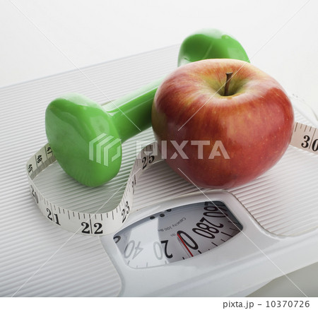 Studio shot of apple, scale, tape measure and dumbbell Studio shot of apple, scale, tape measure and dumbbell 10370726