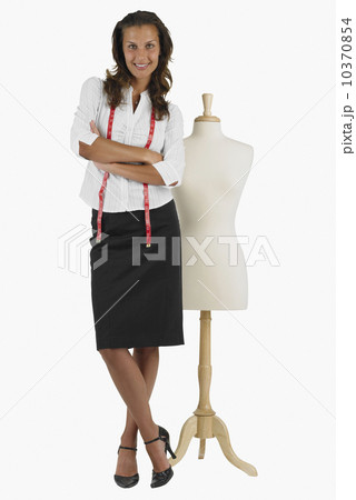 Seamstress standing next to dress dummy Seamstress standing next to dress dummy 10370854