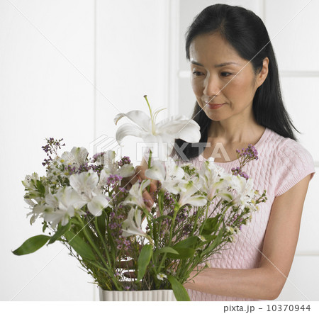 Woman arranging bouquet of flowers 10370944