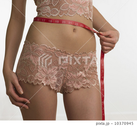 Woman in underwear measuring waist 10370945