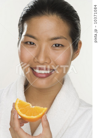Portrait of a woman eating orange slice 10371084