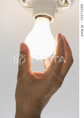 Close up of lightbulb being screwed in  10371089