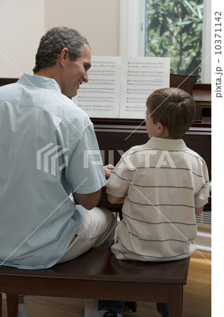 Father and young son playing piano Father and young son playing piano 10371142
