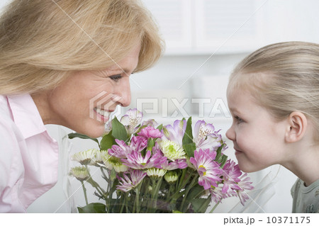 Grandmother and young granddaughter smelling bouquet of flowers Grandmother and young granddaughter smelling bouquet of flowers 10371175