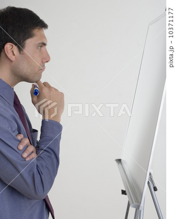 Businessman contemplating what to write 10371177