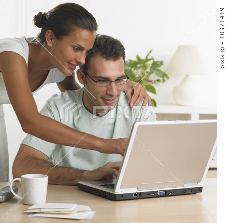 Couple using laptop at table Couple using laptop at table 10371419