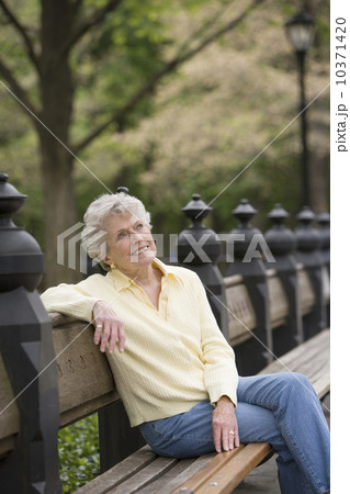 Portrait of woman sitting on park bench Portrait of woman sitting on park bench 10371420
