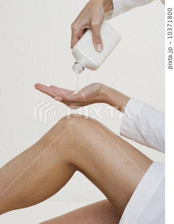 Woman pouring lotion into hand Woman pouring lotion into hand 10371800