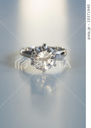 Diamond like ring in six pronged silver setting on table Diamond like ring in six pronged silver setting on table 10371940