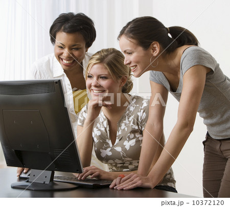 Multi-ethnic women looking at computer 10372120