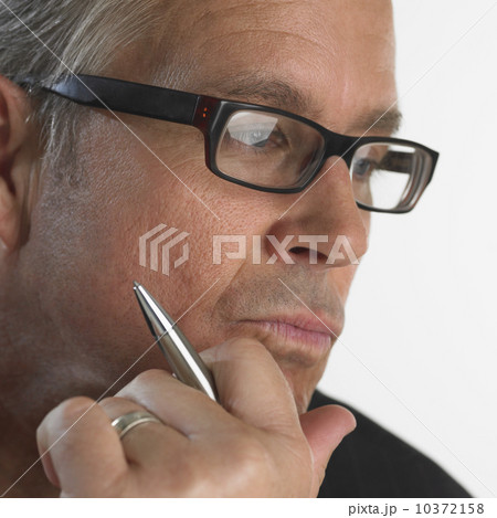 Close up of man holding pen with chin in hand 10372158