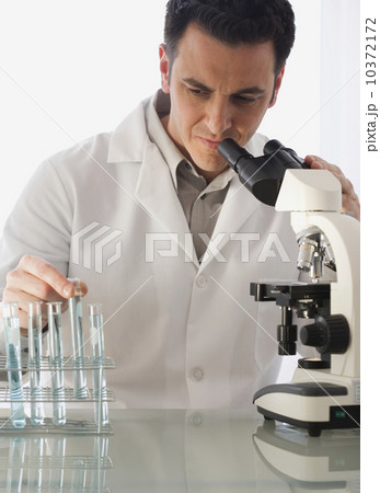 Male scientist looking at vials 10372172