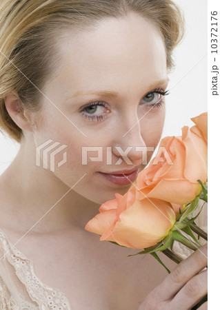 Close up of woman smelling flowers Close up of woman smelling flowers 10372176