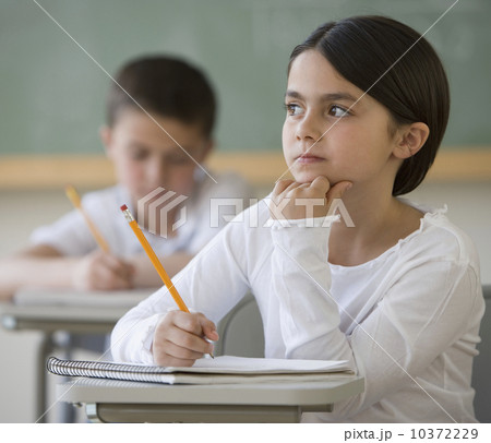 Girl thinking at desk in classroom Girl thinking at desk in classroom 10372229