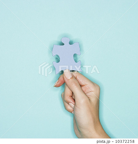 Woman holding jigsaw puzzle piece 10372258