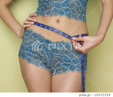 Woman in underwear measuring waist 10372339