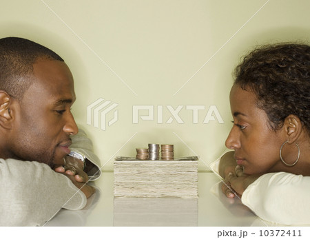 Couple looking at pile of money Couple looking at pile of money 10372411