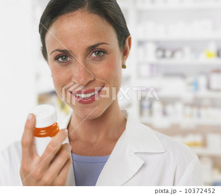 Close up of female pharmacist holding medication 10372452