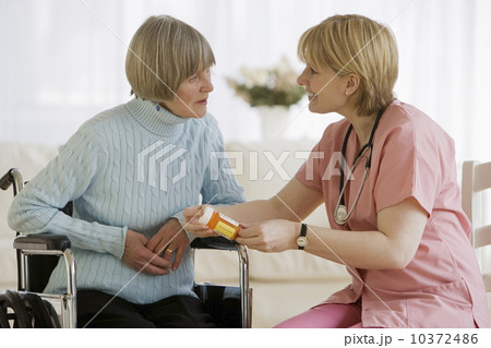 Nurse discussing medication with senior woman 10372486