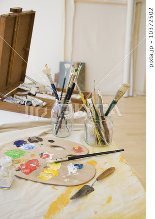Artist’s palette and paintbrushes on table 10372502