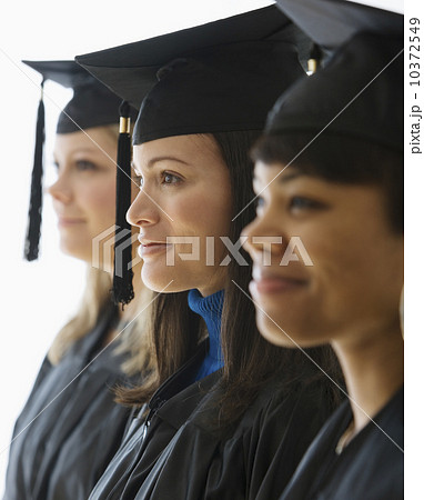Multi-ethnic women wearing graduation cap and gown 10372549