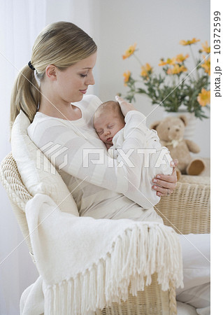 Mother rocking newborn baby in chair Mother rocking newborn baby in chair 10372599