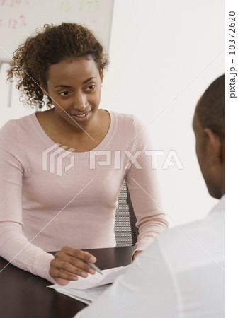 Businesswoman discussing paperwork with coworker 10372620