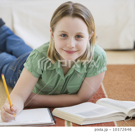Girl doing homework on floor Girl doing homework on floor 10372646
