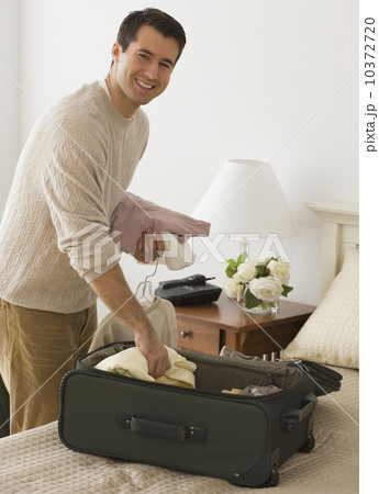 Man unpacking in hotel room 10372720
