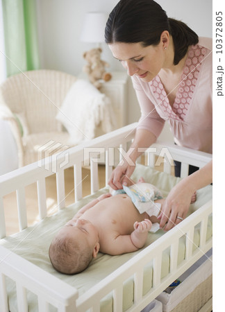 Mother changing baby’s diaper 10372805