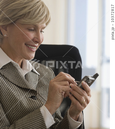Senior businesswoman using electronic organizer 10372817