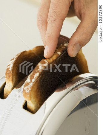 Man taking toast out of toaster 10372890