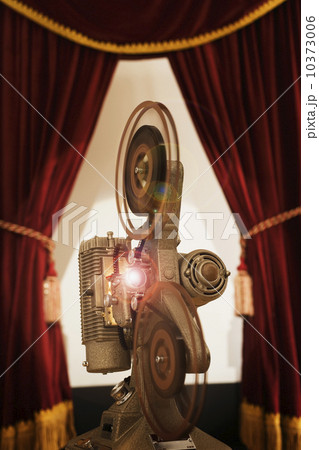 Old fashioned movie projector in between stage curtains Old fashioned movie projector in between stage curtains 10373006