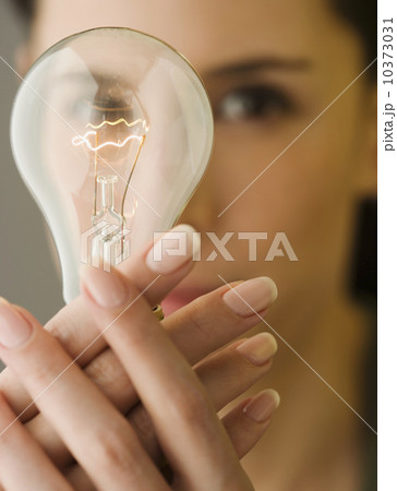 Woman holding light bulb in front of face 10373031