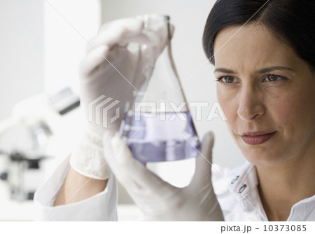 Female scientist looking at liquid in beaker Female scientist looking at liquid in beaker 10373085