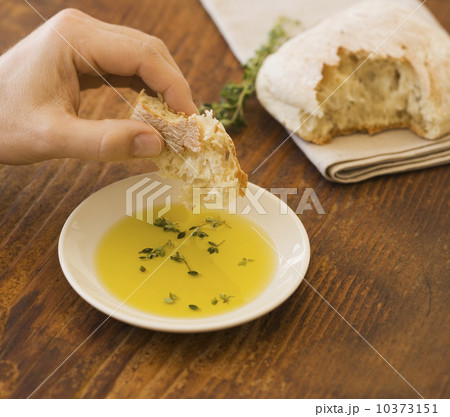 Man dipping bread in olive oil 10373151