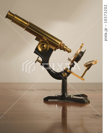 Old fashioned microscope on table 10373202