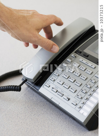 Man reaching for telephone receiver 10373215