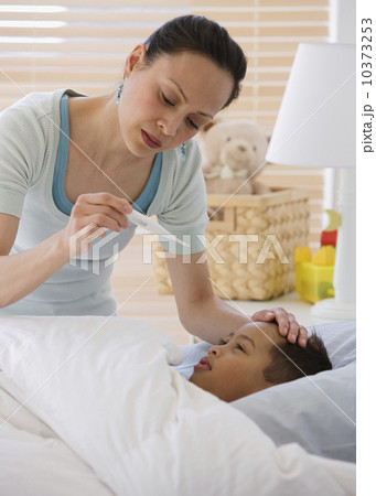Asian mother taking son’s temperature 10373253